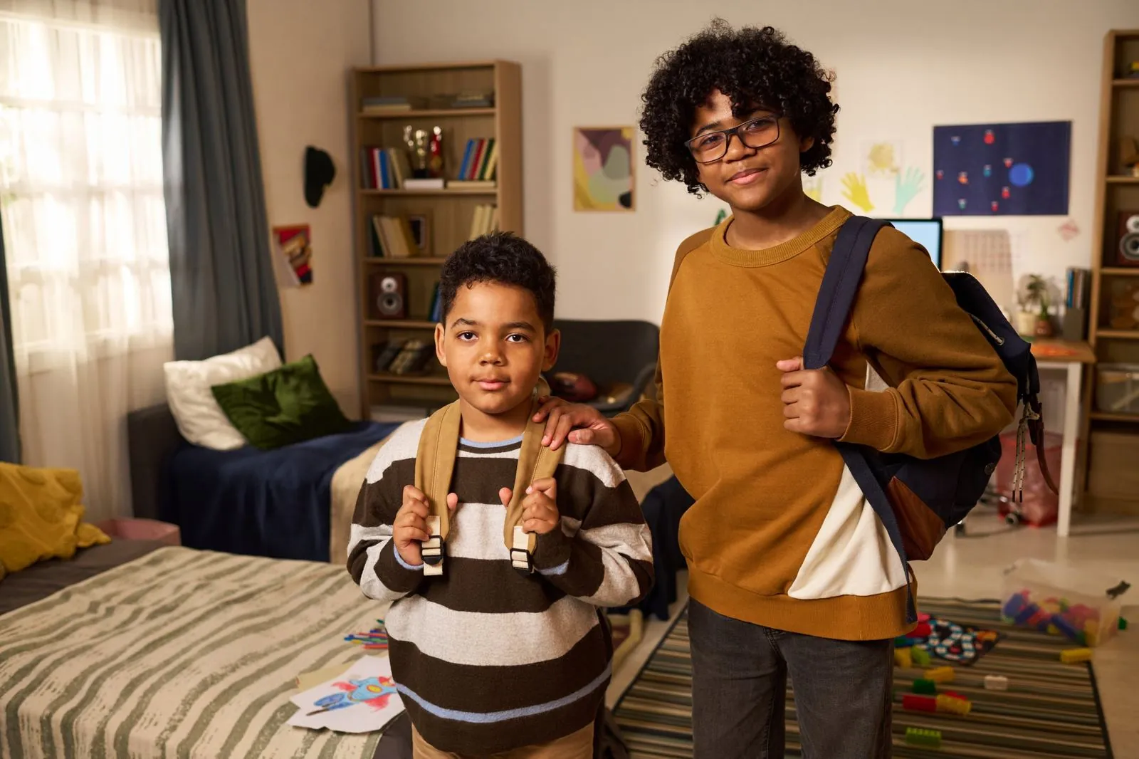 Two brothers with school bags standing in their bedroom